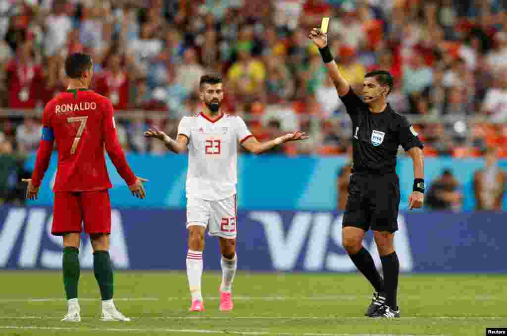 Soccer Football - World Cup - Group B - Iran vs Portugal - Mordovia Arena, Saransk, Russia - June 25, 2018 Portugal's Cristiano Ronaldo is shown a yellow card by referee Enrique Caceres after a decision was referred to VAR REUTERS/Matthew Childs