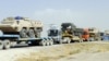 Pakistani drivers guide trailers carrying armored vehicles for NATO forces near Quetta. (file photo) 