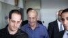 Эхуд Ольмерт (в центре) перед началом судебных слушаний в марте этого года