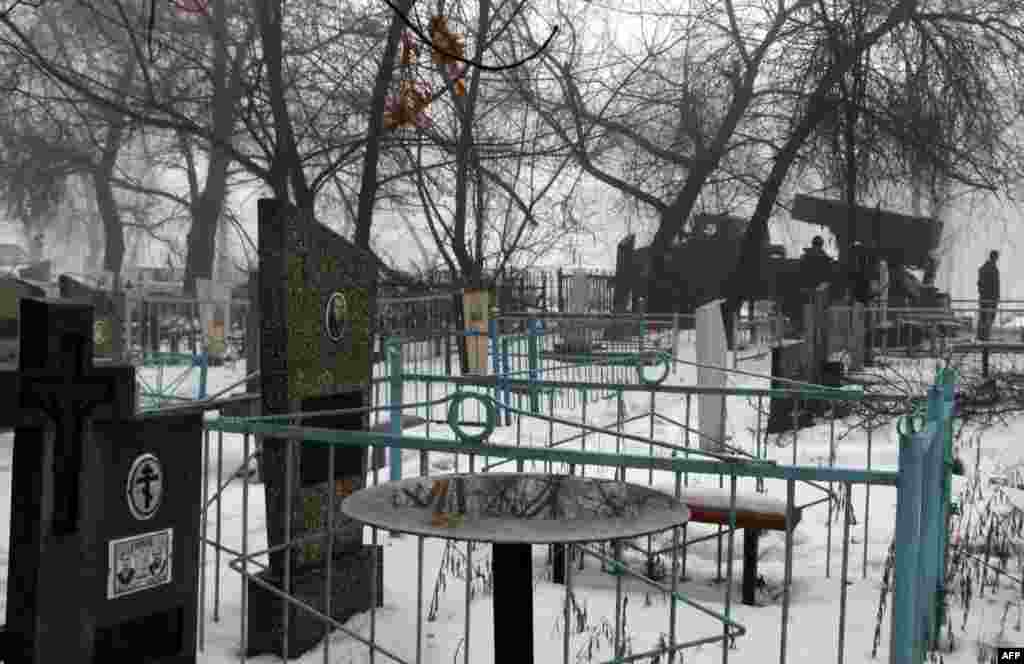 A pro-Russian separatists&#39; Grad multiple-rocket launcher is parked in front of a cemetery in the eastern city of Donetsk. (AFP/Alexander Gayuk)