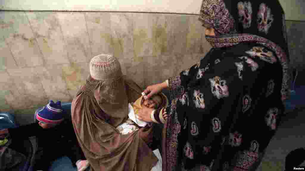 A polio worker gives polio vaccine drops to a child at Lady Reading hospital in Peshawar on December 19. (Reuters/Fayaz Aziz)