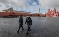 Police officers on a deserted Red Square in front of the Kremlin in Moscow on April 17