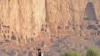 Afghanistan -- A Hazara youth works on a farm in front of the cave-monasteries and the niches where the 174-foot Buddhas, Bamiyan, 25Sep2009