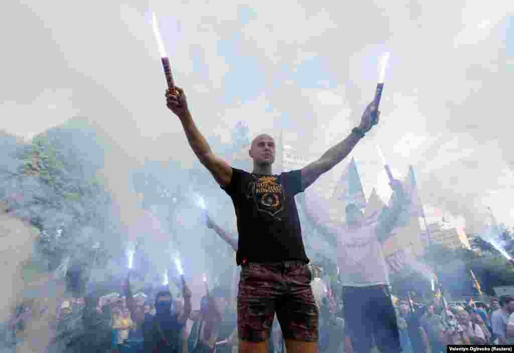 Protesters burn flares as they demand that several Ukrainian lawmakers, suspected of corruption by the prosecutor-general's office, be deprived of parliamentary immunity during a rally near the parliament building in Kyiv on July 11. (Reuters/Valentyn Ogrienko)