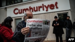 Turkey -- A man reads a copy of Cumhuriyet daily newspaper in front of the newspaper's headquarters in Istanbul during a police operation, October 31, 2016