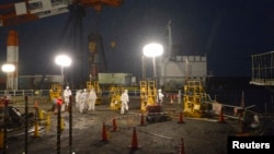 Працівники в захисних костюмах на АЕС «Фукусіма-1»
