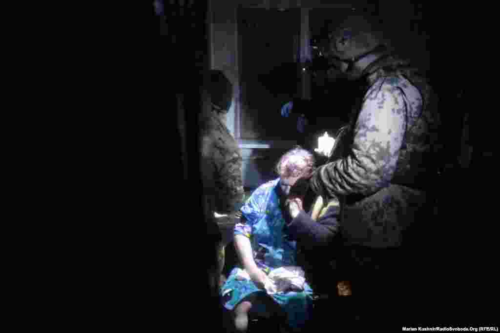 Медики ПДМШ надають першу медичну допомогу літній жінці, пораненій під час артилерійського обстрілу Авдіївки, 3 лютого 2017 року