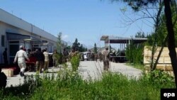 Afghan soldiers shift coffins containing bodies at a military base a day after it was targeted by the Taliban in Balkh Province on April 21.