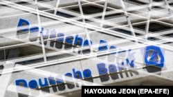 (FILE) - A double exposure picture shows the logo of Deutsche Bank in Berlin, Germany, 25 April 2019 