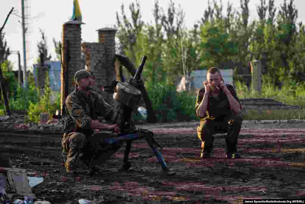 A soldier nicknamed Casanova fires a grenade launcher toward separatist positions in Donetsk from the driveway of a house in Pisky.