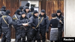 Сотрудники спецназа стоят на месте спецоперации, прошедшей 3 декабря в поселке Боралдай Алматинской области. 4 декабря 2011 года.