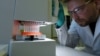 Германиялык биофармкомпаниянын кызматкери COVID-19га каршы вакцинаны сыноодон өткөрүп жатат. 
