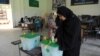 Pakistan -- A woman casts her vote at a polling station during the country's by-election in several constituencies, in Islamabad, August 22, 2013