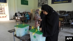 Pakistan -- A woman casts her vote at a polling station during the country's by-election in several constituencies, in Islamabad, August 22, 2013