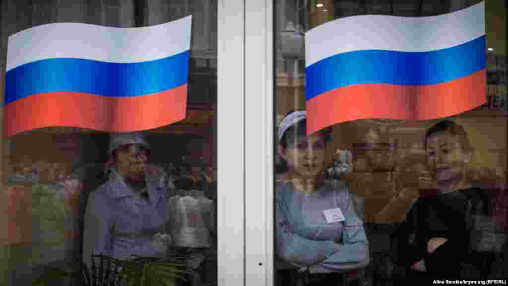 Працівники пельменної на вулиці Катерининській дивляться на мітинг