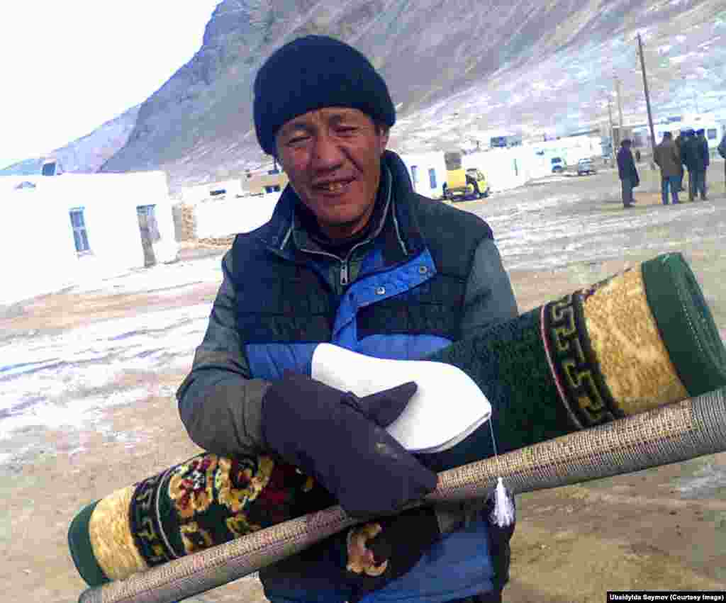 The winner of a game of ankle bones carries his prizes: a small carpet and a Kyrgyz felt hat. At larger tournaments, the prize can be a sheep or a young yak.