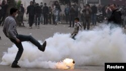 An Egyptian protester kicks a gas canister during clashes with security forces in Cairo.