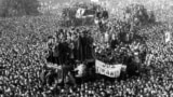 22 Decembrie 1989, Piața Palatului, în fața Comitetului Central al Partidului Comunist Român, astăzi sediul Ministerului de Interne, după fuga cu elicopterul a dictatorului Nicolae Ceaușescu, la orele 12:12-12:13. Un milion de oameni se aflau atunci pe străzile Bucureștiului. 