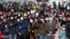 Толпа, собравшаяся на улице, пытается разглядеть церемонию передачи олимпийского огня. Токио, 20 марта 