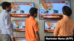 Indian men watch a live broadcast of Indian Prime Minister Narendra Modi on televisions displayed in an electronic store, in Amritsar on March 27.