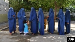 Afghan women voters line up to cast their ballots in Jalalabad on June 14 in the second round of a presidential election that has been marred by fraud allegations.