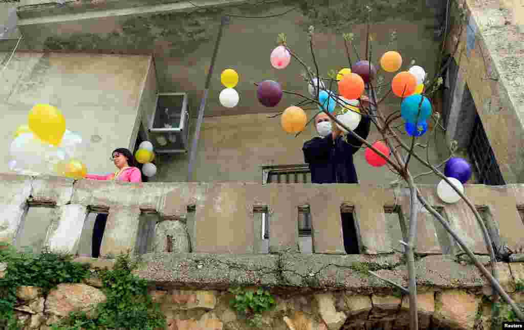 Ukrašavanje drveta balonima na Uskrs u hradu Jezzine u južnom Libanonu, 12. april, 2020.