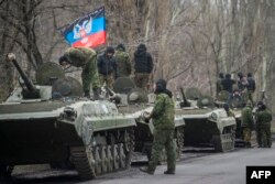 Militari separatiști cu steagul din Donețk.