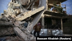 A person inspects damaged building in the besieged town of Douma, Eastern Ghouta, Damascus, Syria February 20, 2018.