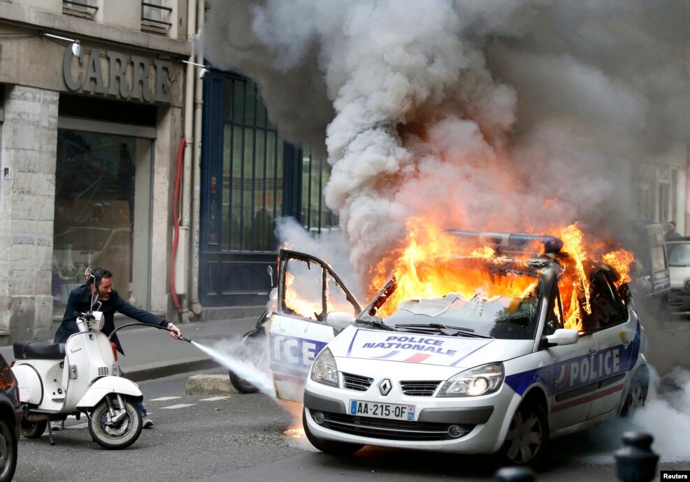 Një makinë policie digjet gjatë një demonstrate kundër dhunës policore dhe reformës franceze të punës në Paris, 18 maj 2016.