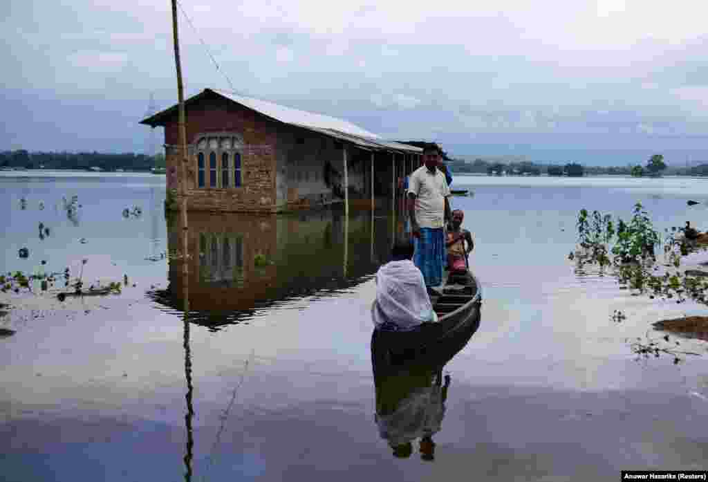 Villagers are transported on a boat toward a safer place at a flooded village in Nagaon district in the northeastern state of Assam, India. (Reuters/Anuwar Hazarika)