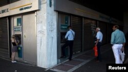 Афіни, ніч на 17 липня 2015 року: черги перед банкоматами під закритим банком і написи «€ = 卐»