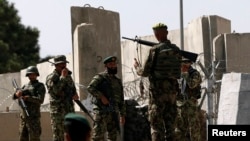 Afghan soldiers keep watch at the gate of a British-run military training academy Camp Qargha, in Kabul August 5, 2014.