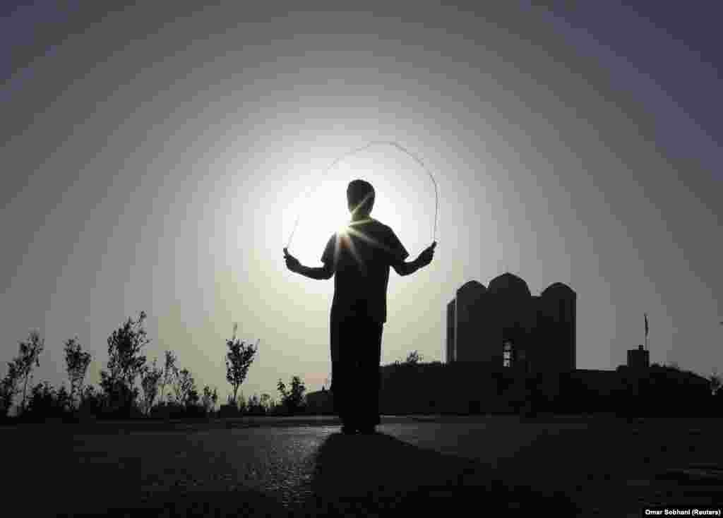 An Afghan boy exercises early in the morning on a hilltop in Kabul. (Reuters/Omar Sobhani)