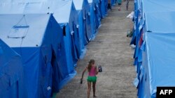Ukraine -- A girl carries a kettle at a temporary facility for refugees form Eastern Ukraine, 20 km outside from the Crimean capital Simferopol, July 17, 2014