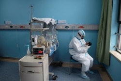 A nurse attends to a baby with COVID-19 at an isolation ward in Wuhan Children's Hospital on March 16.