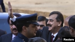Pakistani Prime Minister Yusuf Raza Gilani waves toward reporters after arriving at the Supreme Court in Islamabad on January 19.
