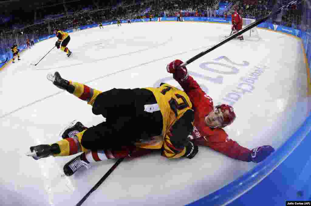 Ice Hockey Men: Brooks Macek (12), of Germany, collides with Russian athlete Bogdan Kiselevich (55) during the third period of the men's gold medal hockey game at the 2018 Winter Olympics, Sunday, Feb. 25, 2018, in Gangneung, South Korea. (AP Photo/Julio Cortez)