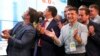 Ukrainian President Volodymyr Zelenskiy (center) applauds with his team as they look at the election results at his party's headquarters in Kyiv on July 21.