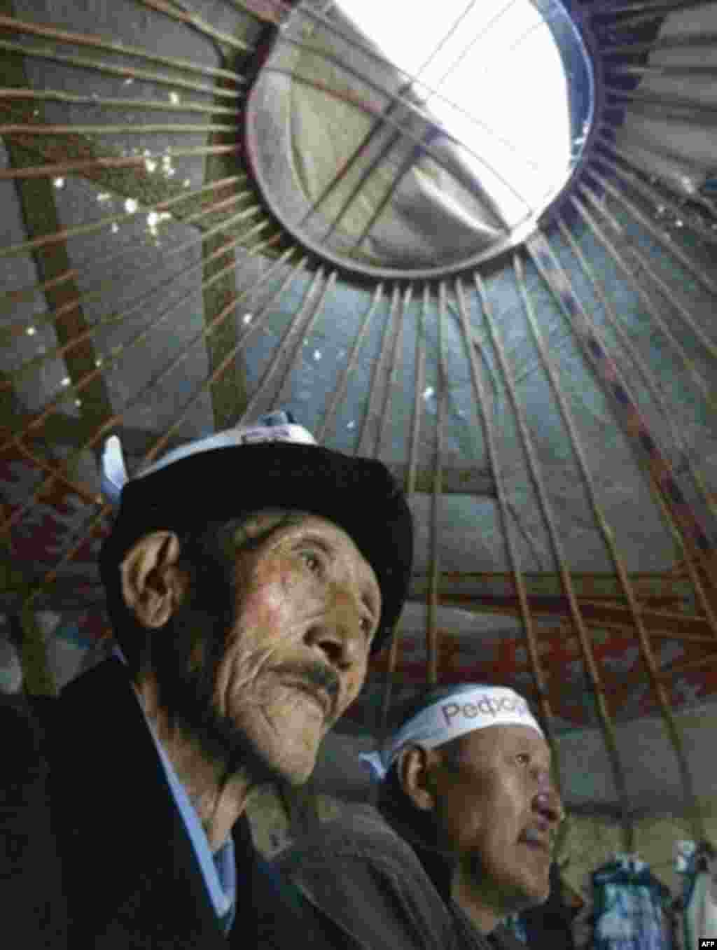 Kyrgyzstan -- Kyrgyz opposition supporters sit inside a traditional yurt tent built by hunger strickers in front of the Parliament in central Bishkek, 07Apr2007. - Kyrgyz protesters camped out in traditional yurts in front of the parliament building in Bishkek during massive demonstrations in April 2007. The hunger strikers and other opposition activists were demanding the resignation of President Kurmanbek Bakiev, saying he had failed to fulfill his promises of democratic reform.