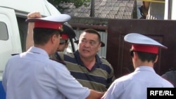 Ramazan Esergepov is escorted by police to a courthouse in Taraz in August.