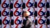 A passerby walks past election posters of the Serbian Progressive Party's (SNS) top candidate for the presidential election, Serbian Prime Minister Aleksandar Vucic, in Belgrade.