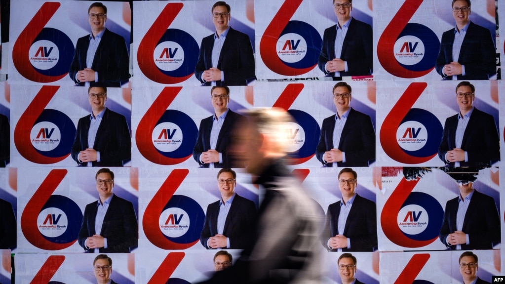 A passerby walks past election posters of the Serbian Progressive Party's (SNS) top candidate for the presidential election, Serbian Prime Minister Aleksandar Vucic, in Belgrade.