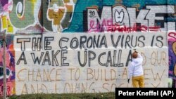 Graffiti la Munchen: „Coronavirus este un semnal de deșteptare și șansa noastră de a construi o societate nouă și plină de iubire”.