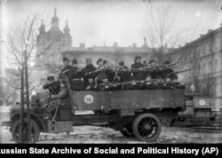 Members of the revolutionary Red Guards pose for a photo with their arms at the Smolny Institute building, which was chosen by Vladimir Lenin as Bolshevik headquarters during the October Revolution in 1917.