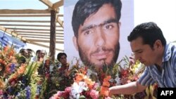 Afghanistan -- An Afghan journalist places flowers in front of a photograph of the late Afghan journalist Abdul Samad Rohani, Kabul, 12Jun2008