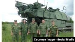 Зенитно-ракетный комплекс «Бук» и группа российских военнослужащих. Фото из доклада группы Bellingcat. 