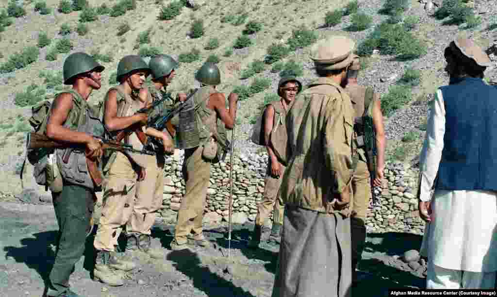 Млади съветски войници отстраняват мините от път в Афганистан. Военното нахлуване на СССР в Афганистан започва в опит да бъде подкрепен комунистическият режим в Кабул.