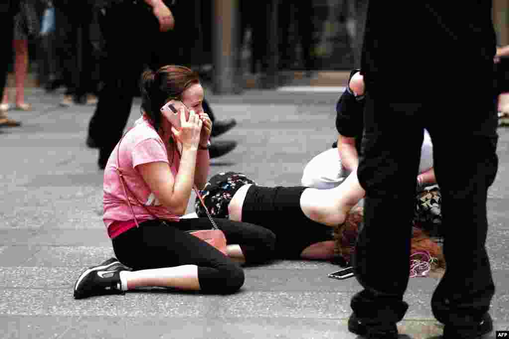 A woman makes a phone call as others attend to an injured person after a car plowed into pedestrians on New York's Times Square on May 18. (AFP/Jewel Samad)
