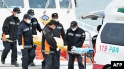 Спасатели несут тела погибших при крушении судна Sewol