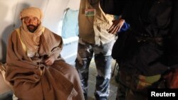 Muammar Qaddafi's son, Saif al-Islam, sits in a plane in Zintan on November 19, after his capture.